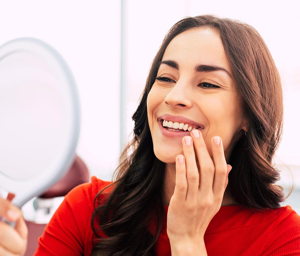Brunette looking at her smile in the mirror